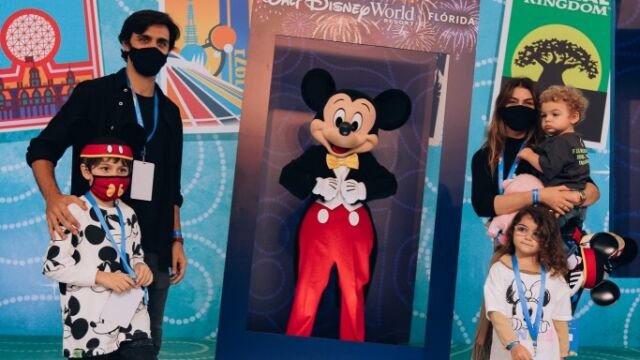 Felipe Simas, Mariana Uhlmann e filhos ao lado de Mickey Mouse