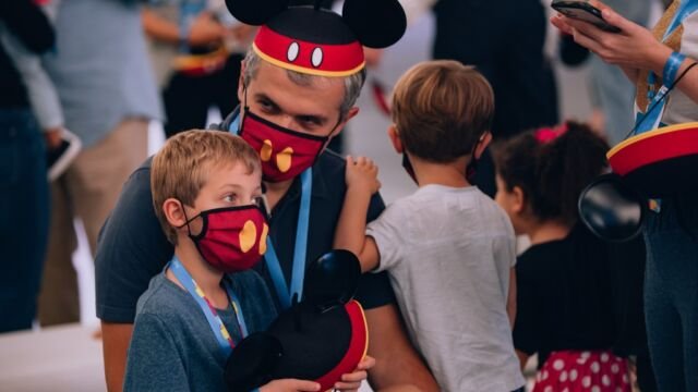 Pai e filho curtem o evento com chapéu e máscara do Mickey